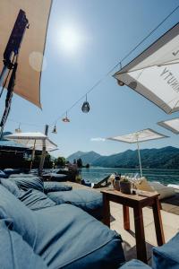a group of beds under umbrellas and a table at Seehotel Schlierseer Hof in Schliersee
