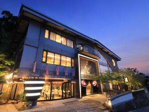a blue building with lights on it at night at Kikunoya in Miyajima