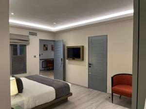 a bedroom with a bed and a tv and a chair at Yara Nuwara Eliya in Nuwara Eliya