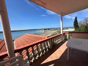 a balcony with a table and a view of the beach at Villa M, App 4 - 6 persons direct on the seaside, 1st floor in Ljubač