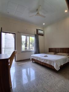a bedroom with a large bed and a window at WoodsPicker in Rishīkesh