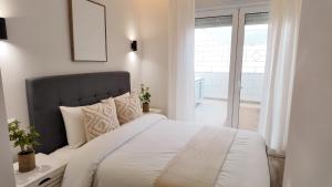 a bedroom with a large white bed and a window at The Eight Element Suites & Lofts in Madrid