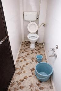 a dirty bathroom with a toilet and a blue bowl at Hotel Shree in Indore