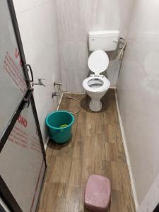 a small bathroom with a toilet and a bucket at Hotel Shree in Indore