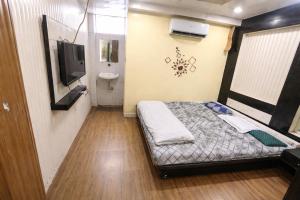 a small room with a bed and a tv at Hotel Shree in Indore