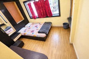 a small room with a bed and a window at Hotel Shree in Indore