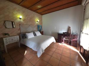 a bedroom with a white bed and a tv at La Moreneta in Casas de Haro +22 photos