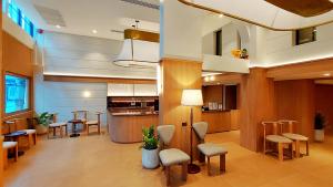 a lobby with chairs and tables and a kitchen at Marwin Monique Hotel in Bangkok