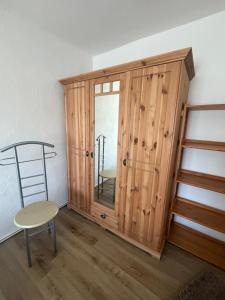 a room with a wooden cabinet and a chair and a ladder at Ferienwohnung Fam.Stecher in Malschwitz