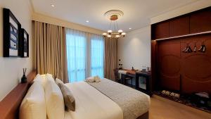 a bedroom with a large bed and a desk at Marwin Monique Hotel in Bangkok