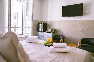 a room with a table with two chairs and a television at Stradun Main Street Residence in Dubrovnik