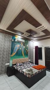 a bed in a room with a painting on the wall at MMB Hotel in Bikaner