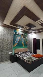 a bed in a room with a painting on the wall at MMB Hotel in Bikaner