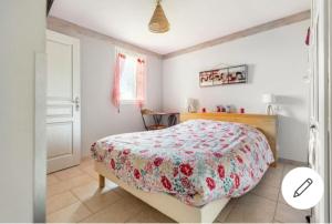 a bedroom with a bed with a floral bedspread at Chez Cathie à Muret in Muret