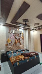 a bedroom with a bed with a painting on the wall at MMB Hotel in Bikaner