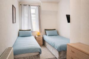 two beds in a small room with a window at Cadeby Lodge in Blackpool