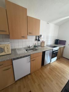a kitchen with wooden cabinets and stainless steel appliances at Ferienwohnung Fam.Stecher in Malschwitz