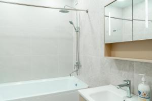 a white bathroom with a shower and a sink at Sapphire Residence in Khujand +9 photos