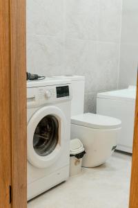 a bathroom with a washing machine and a toilet at Sapphire Residence in Khujand