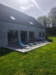 a group of chairs sitting on a patio next to a building at La randonnée in Beaumont