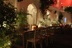 a restaurant with a wooden table and chairs with lights at Chirmi Palace - A Heritage Home in Jaipur
