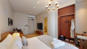 a bedroom with a large white bed and a television at Marwin Monique Hotel in Bangkok