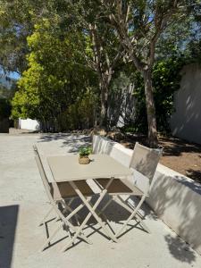 a table and two chairs with a potted plant on it at SUPERBE T2 moderne - ENTREE DE VILLE - PARKING PRIVE in Ajaccio