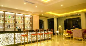 a restaurant with a bar with chairs and bottles of alcohol at The Grand Kandyan in Kandy