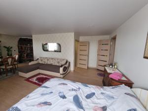 a bedroom with a bed and a living room at Natural oasis in Vilainiai