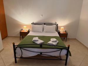 a bedroom with a bed with towels on it at Villa Alexandra in Agia Marina Aegina