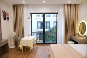 a hotel room with a table and a balcony at AnChi Homestay in Hòa Bình +10 photos