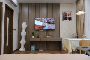 a living room with a tv on a wall at AnChi Homestay in Hòa Bình