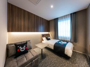 ein Hotelzimmer mit einem Bett und einer Couch in der Unterkunft THE STILL HOTEL - Opening April 3, 2026 in Ozu