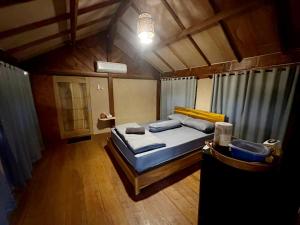a bedroom with a bed in a room with wooden floors at Cozy cove hut in Pulau Sarang