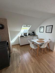 a living room with a table and chairs and a kitchen at Im Wald in Gleiszellen-Gleishorbach