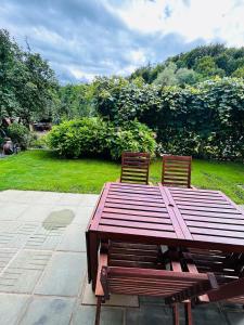 a wooden table and two chairs next to a garden at AS Apartment Free Parking and Peaceful Nature near Ljubljana in Škofljica