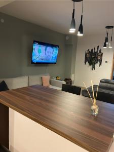 a dining room with a table and a tv on the wall at AS Apartment Free Parking and Peaceful Nature near Ljubljana in Škofljica
