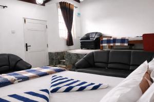 a living room with a bed and a couch at Hill House Haldummulla in Badulla