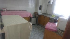 a small kitchen with two beds and a sink at Rooms Melide in Melide