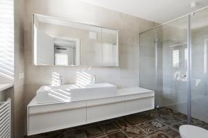 a bathroom with a white sink and a mirror at Forgotten Garden Villa in Portorož