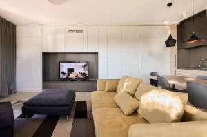 uma sala de estar com um sofá e uma televisão em Forgotten Garden Villa em Portorož