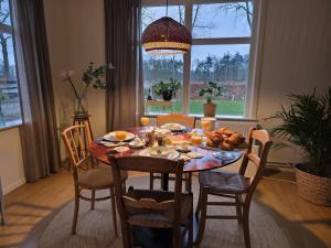 a dining room with a table with food on it at B&B Grolloo in Grolloo +18 photos