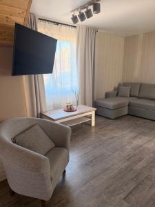 a living room with a chair and a couch at Alexandra Forest Lake House in Konsu