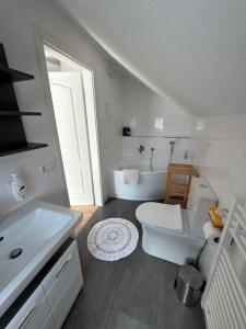a white bathroom with a toilet and a sink at Im Wald in Gleiszellen-Gleishorbach +8 photos