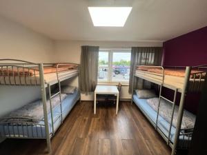 a room with three bunk beds and a table at Pension Baron in Fürth