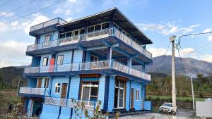 a blue building with a balcony on top of it at Bhadraj Valley Homestay in Dehradun