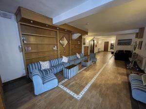 a living room with blue couches and a couch at Hotel Chalet du Soleil in Torgnon