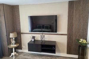 a living room with a flat screen tv on a wall at Beijerse inn in Nieuw-Beijerland