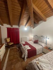 a bedroom with two beds and a red curtain at Hotel Chalet du Soleil in Torgnon