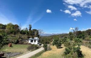 a house in the middle of a field at Bhadraj Valley Homestay in Dehradun +17 photos